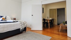 A bedroom with a bed, bedside table, and a small rug. - U Suites on Cuba (Wellington)