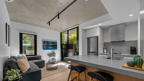 Una cocina moderna con una isla grande, taburetes de bar y una estufa integrada.
