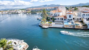 Un hotel frente al mar con un puerto deportivo, que cuenta con piscina, muelle privado y vistas al mar y a las montañas.