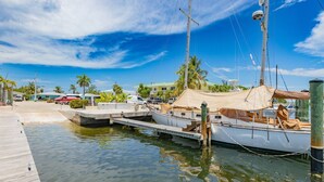 A marina with boats docked, a wooden dock, and a clear blue sky.