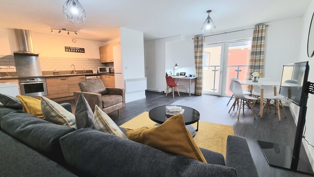 A modern living room with a sofa, coffee table, and a dining area with chairs and a table. - Spacious London Apartment, 5mins from metro (London)