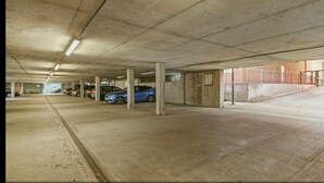 A multi-level parking garage with concrete pillars and a few parked cars. - Spacious London Apartment, 5mins from metro (London)