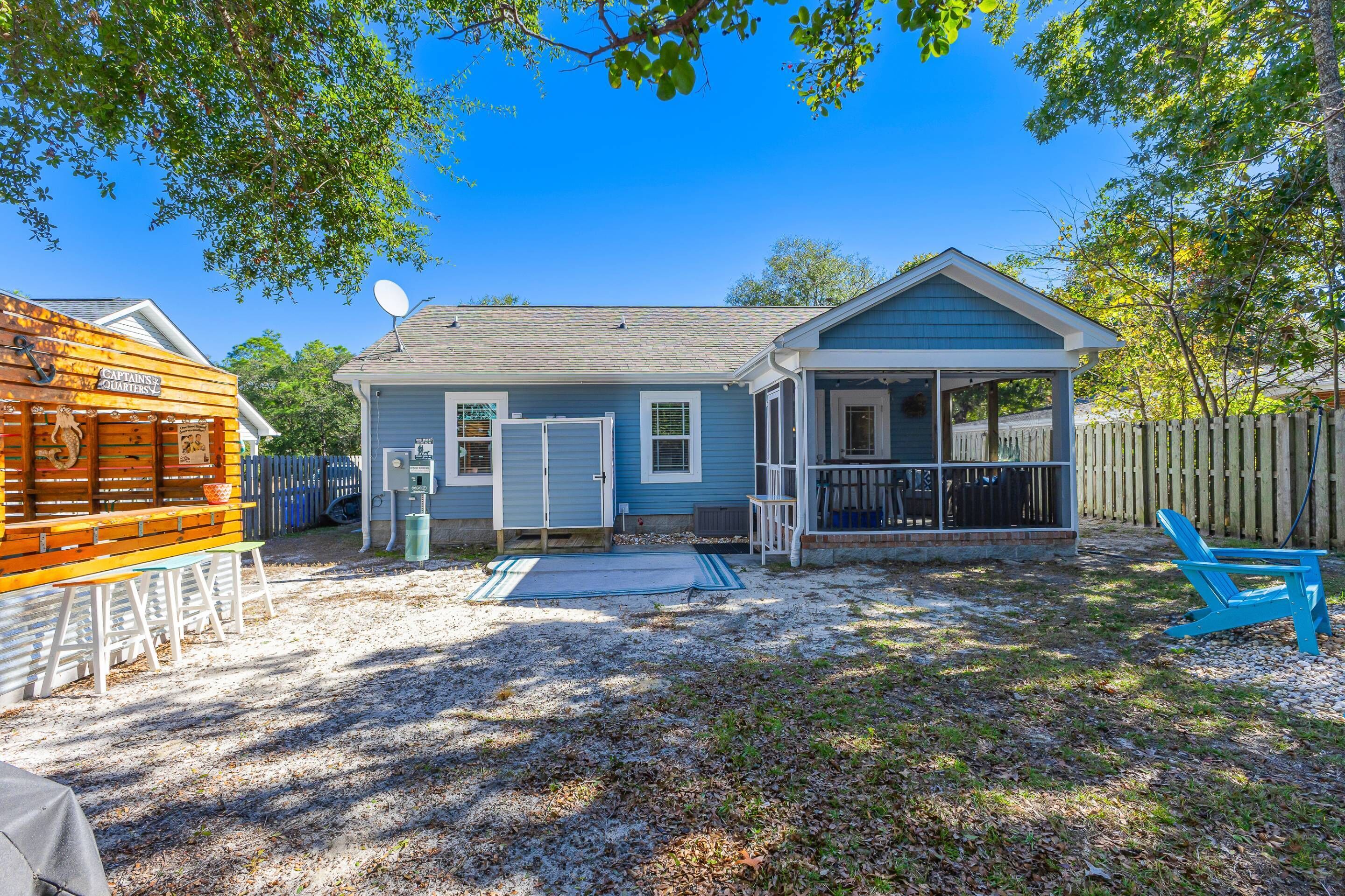 A single-story house with a covered porch, a satellite dish, and a wooden deck.