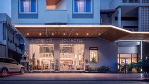 A hotel with a modern facade, large windows, and a covered entrance area. - Joli Hotel (Phnom Penh)