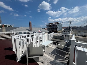 A rooftop deck with outdoor seating, a flag, and a view of the cityscape. - 1.5 Blocks from Ocean Unit #3 Great Location 2 Bedroom Apartment  (Seaside Heights)
