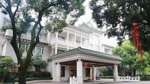 A traditional-style building with a covered entrance, large windows, and a balcony. - Guangdong Yingbin Hotel (Guangzhou)