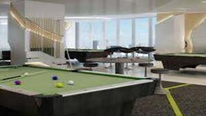 A pool table in a modern indoor setting with a clear view of the sky through large windows. - Green Residences  Taft (Manila)