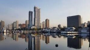 A city skyline with high-rise buildings and a marina with boats. - Green Residences  Taft (Manila)