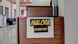 Ein Empfangsschalter mit einem Schild, auf dem 'Malora Homestay' steht.