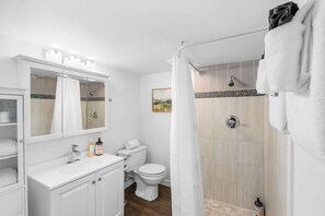A bathroom with a shower, toilet, and sink. - WARA01 - Raven in Law, Picturesque lower unit (Seattle)