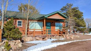 A lodge with a wooden exterior, a porch, and a clear sky. - Marr's Mountain Cabins - Cabin 1 (Red Feather Lakes)