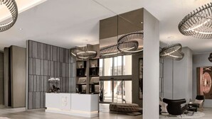 Un salon moderne doté d’un îlot central, d’étagères intégrées et d’une grande fenêtre.