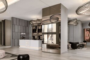 Ein modernes Wohnzimmer mit einer zentralen Kücheninsel, integrierten Regalen und einem großen Fenster.