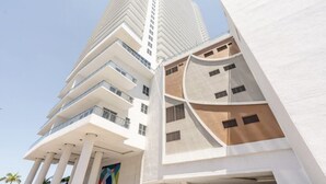 Un immeuble moderne de grande hauteur, doté de nombreux balcons et d’une conception architecturale originale.