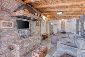 A rustic interior with a stone fireplace, wooden ceiling beams, a television mounted on the wall, and a sofa. - Rustic Home Izabel With Pool (Pazin)