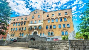 Un edificio grande y antiguo con numerosas ventanas y fachada de piedra.