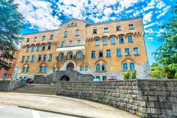 A large, historic building with multiple windows and a stone facade.