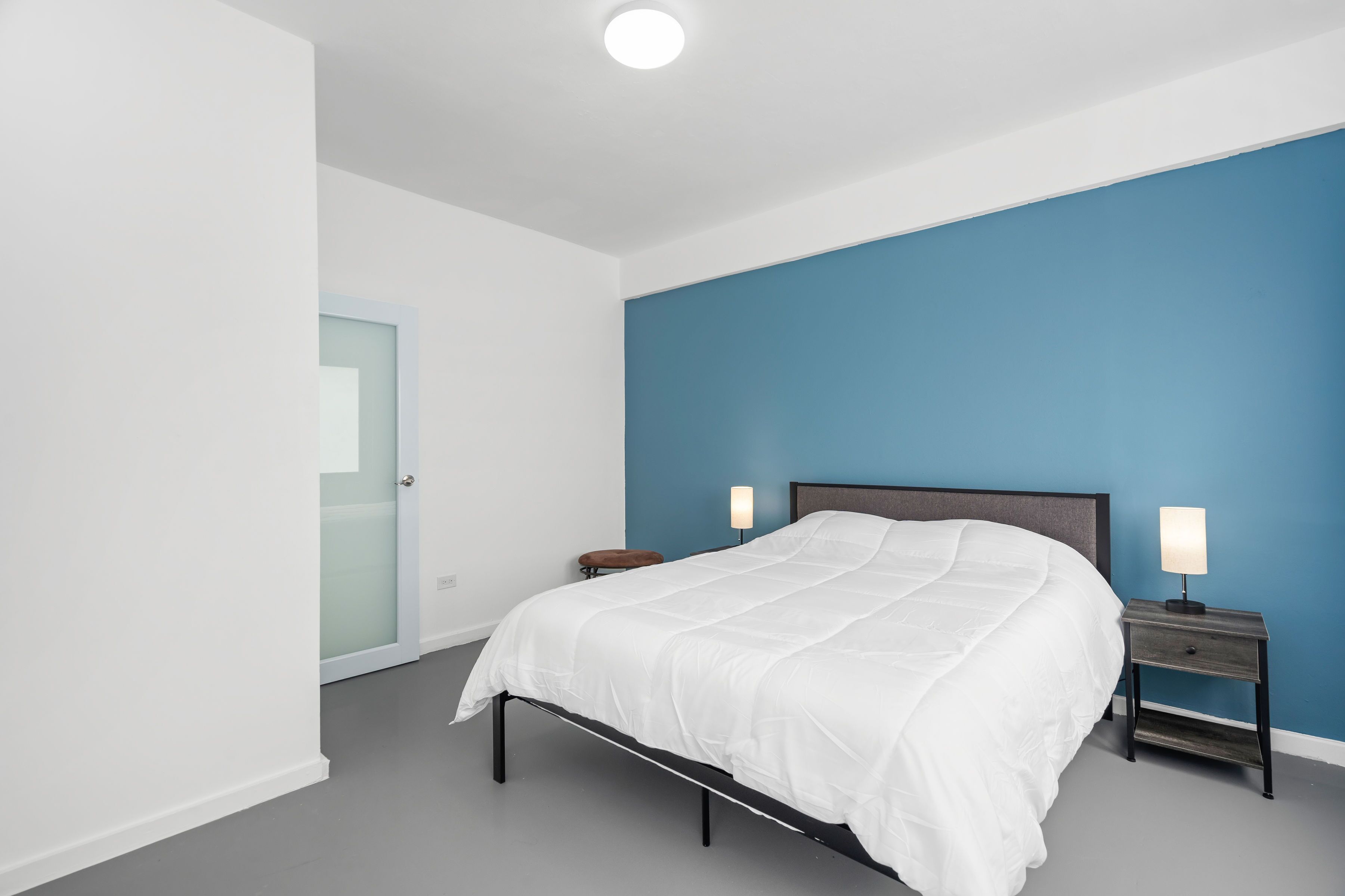 Ein Schlafzimmer mit einem Bett, Nachttischen und einem Beistelltisch.