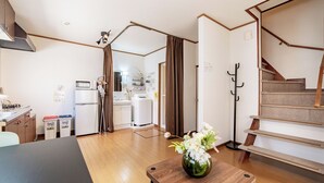 Eine moderne Küche mit Mikrowelle, Kühlschrank und einem Essbereich mit Tisch und Vase.