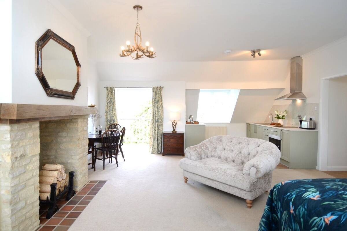 A spacious living room with a fireplace, a dining area, and a kitchen.