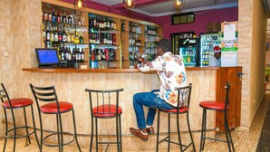 A bar area with a bartender, a computer, and a variety of bottles on shelves. - Eaglesvale Resort Naivasha (Naivasha)