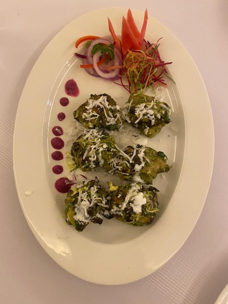 Un plato con alimentos, posiblemente un plato de verduras y queso, y una composición decorativa de vegetales.