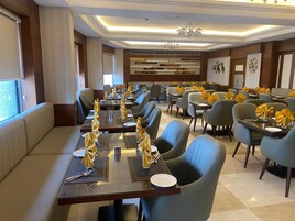 A dining area with long tables, chairs, and yellow napkin decorations.