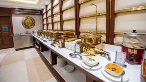 Montaje de bufé con distintas estaciones de comida, incluyendo una estación de sopas y una olla arrocera.