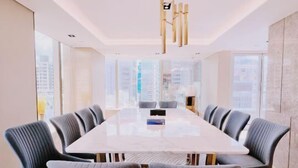 Una sala de conferències moderna amb una taula rectangular gran, cadires tapissades de color gris i un penjoll de bambú únic.