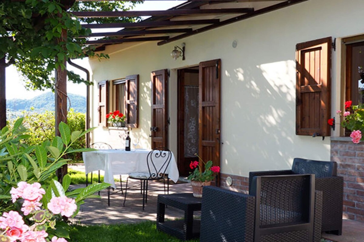 A patio area with a table and chairs, a small brick wall, and a view of the mountains.