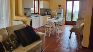A compact living space with a kitchenette, a dining area, and a sofa. - Tranquil Farmhouse in Umbria (Monte Santa Maria Tiberina)