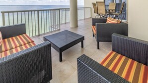 Un balcon doté de meubles en osier et offrant une vue sur l’océan.