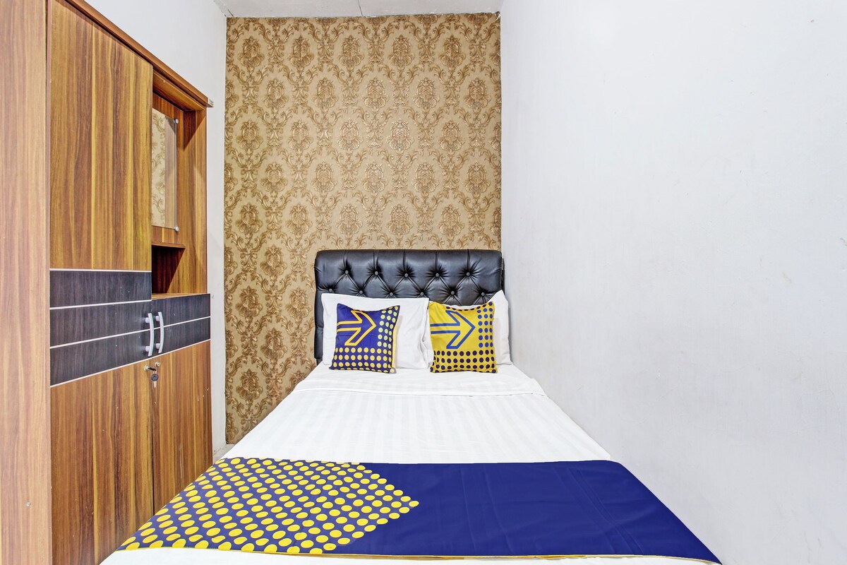 Un dormitorio con cama, armario y papel tapiz estampado.