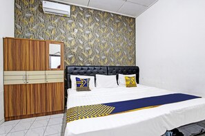 Un dormitorio con cama, armario y aire acondicionado instalado en la pared.