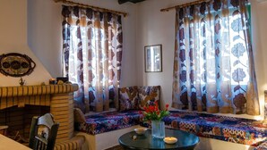 Ein gemütliches Wohnzimmer mit Kamin, einer Sofagarnitur und einem Tisch mit Blumen.