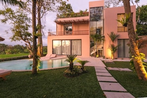 A modern two-story house with a swimming pool, surrounded by lush greenery and palm trees. - Sealuna Villas (Tabanan)