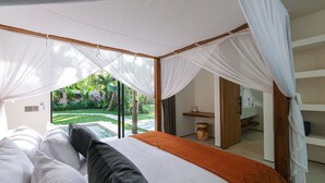 A bedroom with a bed, white curtains, and a view of a garden. - Sealuna Villas (Tabanan)