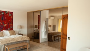 A bedroom with a bed, a bench, a mirror, and a wardrobe. - Large fantastic house with a garden, a pool and beautiful views (Vence)
