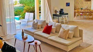 A modern living room with a sofa, coffee table, and dining area. - Large fantastic house with a garden, a pool and beautiful views (Vence)