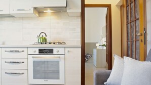 A modern kitchen with a gas stove, oven, and a kettle. - GuestHost - Casa Matabù - luminoso bilocale x3 (Cernusco sul Naviglio)