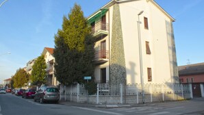 A multi-story building with a balcony, parked cars, and a streetlight. - GuestHost - Casa Matabù - luminoso bilocale x3 (Cernusco sul Naviglio)