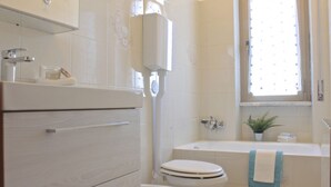 A bathroom with a toilet, sink, and bathtub. - GuestHost - Casa Matabù - luminoso bilocale x3 (Cernusco sul Naviglio)