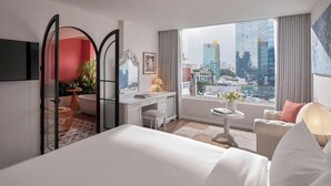 A hotel room with a bed, a desk, a chair, a small table, and a view of the cityscape. - Silverland Mây Hotel (Ho Chi Minh City)