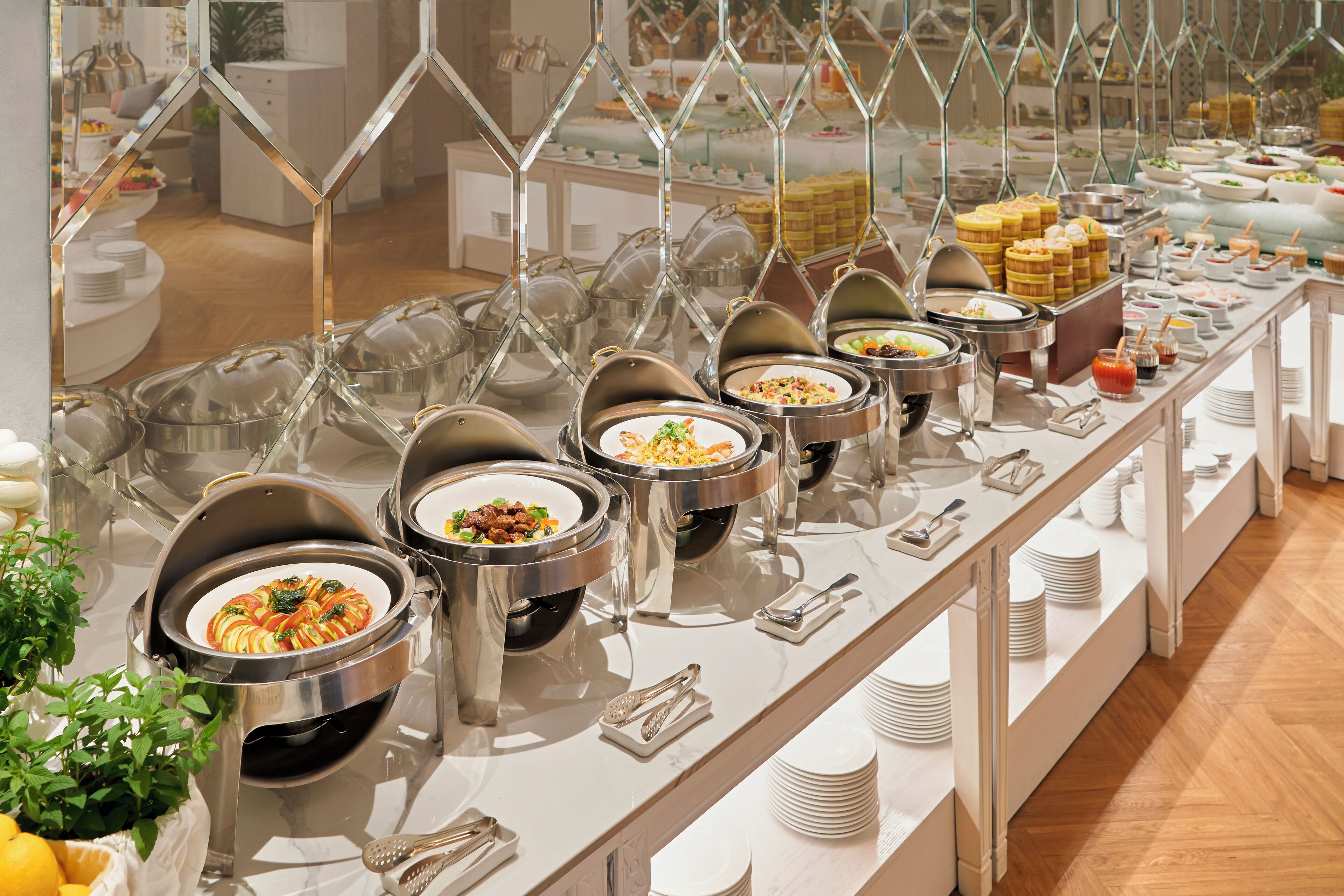 A buffet setup with multiple serving stations, each with a variety of dishes and utensils.