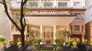 The exterior of the Silverland May Hotel with a grand entrance, multiple floors, and lush landscaping. - Silverland Mây Hotel (Ho Chi Minh City)