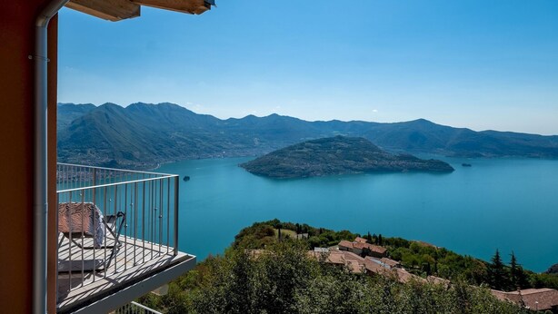 Ein Balkon mit Blick auf einen See und Berge.