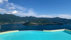 A clear blue sky, a swimming pool, and a mountainous landscape with a body of water. - Dali in Spiglia With 2 Bedrooms and 1 Bathrooms (Parzanica)