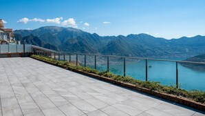 Eine Terrasse mit Blick auf Berge und einen See.