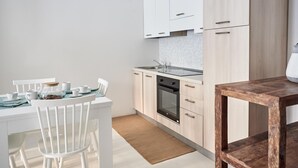 A modern kitchen with white cabinetry, a built-in oven, and a small sink. - Cala Moresca in Golfo Aranci (Golfo Aranci)