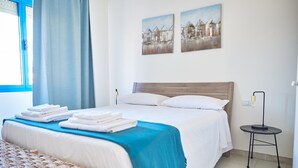A hotel room with a bed, a bedside table, a lamp, and two paintings on the wall. - Marinella in Golfo Aranci (Golfo Aranci)